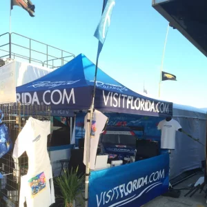 Blue tent outdoors with logos and flags