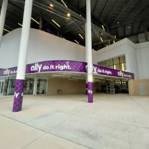Exterior of a building with purple logos and wall wraps