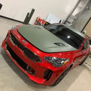 Red car in garage with green hood and top