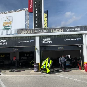 open garage with logos and people working